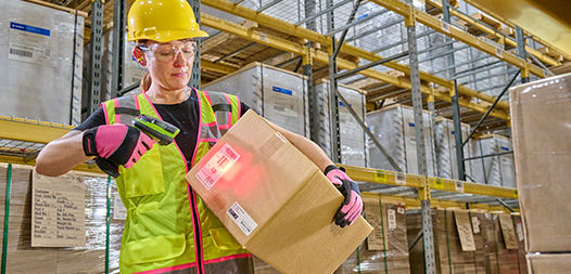 Person in warehouse scanning package