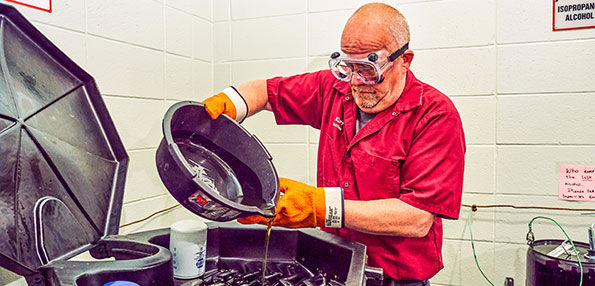Employee Disposing of Oil Wearing J.J. Keller SAFEGEAR PPE Gloves